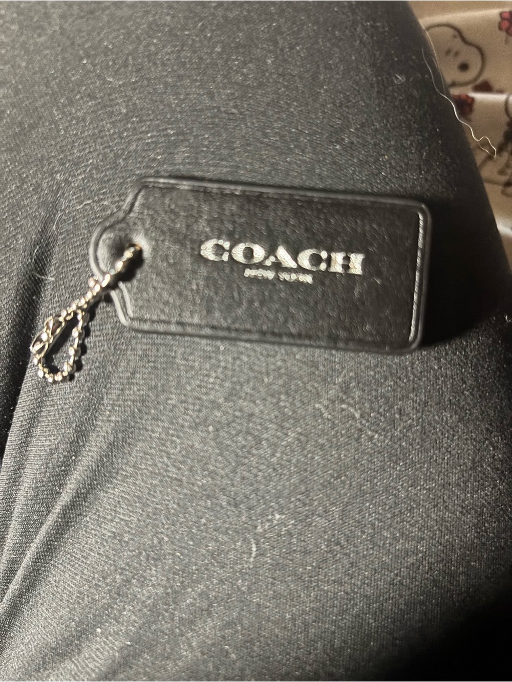 COACH Black Leather Tag with silver writing and chain.